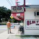 a man standing on a sidewalk next to old tyme grocery in lafayette