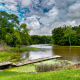 A dock sitting on top of a body of water surrounded by lush greenery