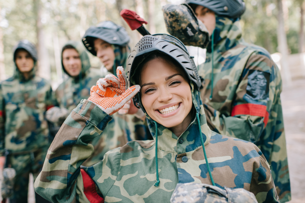 young woman smiling while playing paint ball
